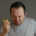 Man eating lemon and making silly faces isolated