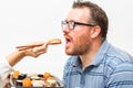 Man eating nagiri salmon with chopsticks