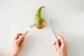 Man eating pear with fork and knife top view. healthy food concept. Healthy products, fruits on a white background. vegetarianism Royalty Free Stock Photo