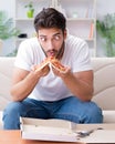 Man eating pizza having a takeaway at home relaxing resting Royalty Free Stock Photo