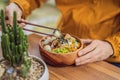 Man eating Raw Organic Poke Bowl with Rice and Veggies close-up on the table. Top view from above horizontal Royalty Free Stock Photo