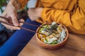 Man eating Raw Organic Poke Bowl with Rice and Veggies close-up on the table. Top view from above horizontal Royalty Free Stock Photo