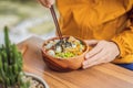 Man eating Raw Organic Poke Bowl with Rice and Veggies close-up on the table. Top view from above horizontal Royalty Free Stock Photo