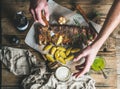 Man eating roasted pork ribs with garlic, holding fork