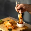 Man Eating Rolls with Sauce Using Chinese Chopsticks. Delicious oriental dish, close up. Eastern Cuisine. Food concept