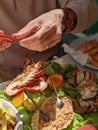 Man eating seafood lobster and prawns at a restaurant in the sun