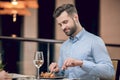 Man eating seafood at the restaurant and looking involved