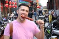 Man eating sugar-coated haws on a stick in China