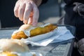 Man eating typical German Friesland deep fried Pollack fish in beer batter as bread bun roll with sauce tartar on wooden table Royalty Free Stock Photo