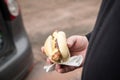 Man eating typical grilled German Bratwurst sausage street food with bread roll bun and mustard on the go Royalty Free Stock Photo