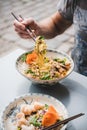 Man eating vietnamese noodle curry with duck with chopsticks