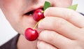 A man eats berries of cherries. Delicious and useful vitamin foo