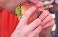 A man eats a big juicy burger. Burger with cheese, vegetables, cutlets close-up Royalty Free Stock Photo