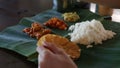 Man Eats Food with Hands from Banana Leaf