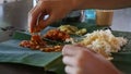 Man Eats Food with Hands from Banana Leaf