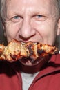 A man eats a juicy fragrant piece of pork kebab on a skewer. Fatty calorie foods