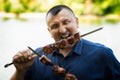 The man eats the meat made on naked flame. Summer river bank Royalty Free Stock Photo