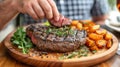 A man eats a steak served with potatoes on a wooden plate in a restaurant. Horizontal format.