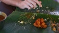 Man Eats up Food and Rolls up Banana Leaf