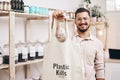 Man at eco friendly grocery store, recycling shopping bag and commitment to climate change at sustainable small business