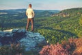 Man on edge of cliff high above misty valley. Travel hiking and Lifestyle. Royalty Free Stock Photo