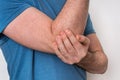 Man with elbow pain is holding his aching arm