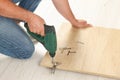 Man with electric screwdriver assembling furniture on floor, closeup Royalty Free Stock Photo