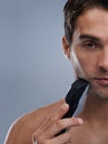 Man, electric shaver and face with closeup studio portrait, grooming and skincare by grey background. Person, model and Royalty Free Stock Photo