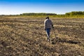 Man with electronic metal detector device working on outdoors background. Close-up photography of searching process