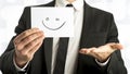 Man in elegant business suit holding up a white card with smiley Royalty Free Stock Photo