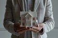 man in an elegant business suit holds model of an apartment building in his palms,hands in close-up,concept of mortgage lending,