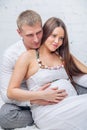 Man is embracing his pregnant wife on the floar Royalty Free Stock Photo