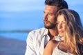 Man embracing his woman from behind on seaside background under Royalty Free Stock Photo