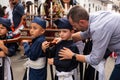 Man embracing a little boy at religious processions in Popayan on Domingo de Ramos