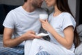 Man embracing woman with coffee cup