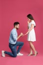 Man with engagement ring making marriage proposal to girlfriend on background