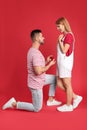 Man with engagement ring making marriage proposal to girlfriend on background