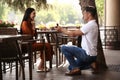 Man with engagement ring making proposal to his girlfriend in outdoor cafe Royalty Free Stock Photo