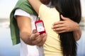 Man with engagement ring making proposal to his girlfriend near river, closeup Royalty Free Stock Photo