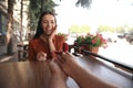 Man with engagement ring making proposal to his girlfriend in outdoor cafe, focus on hands Royalty Free Stock Photo