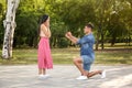 Man with engagement ring making proposal to his girlfriend in park Royalty Free Stock Photo