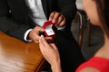 Man with engagement ring making proposal to his girlfriend at table, closeup Royalty Free Stock Photo