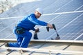 Electrician mounting solar panel on roof of modern house Royalty Free Stock Photo