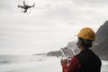 Man engineer flying drone while wearing protective mask during coronavirus outbreak - Focus on tablet