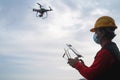 Man engineer flying with drone while wearing safety mask - Focus on right hand