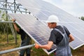 Male workers assembling solar panel system outdoors.