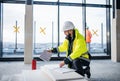 Man engineer with tablet on construction site, looking at blueprints. Royalty Free Stock Photo