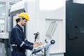 Man engineer using computer controlling cnc machine at workshop. professional male control automated machine process programming Royalty Free Stock Photo