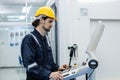 Man engineer using computer controlling cnc machine at workshop. professional male control automated machine process programming Royalty Free Stock Photo