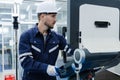 Man engineer using computer controlling cnc machine at workshop. professional male control automated machine process programming Royalty Free Stock Photo